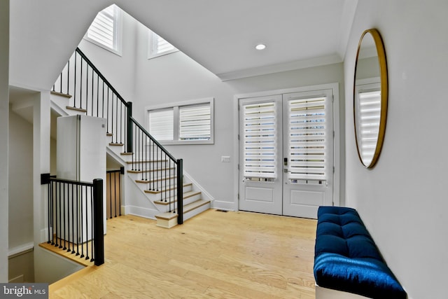 entryway featuring french doors, ornamental molding, and light hardwood / wood-style flooring