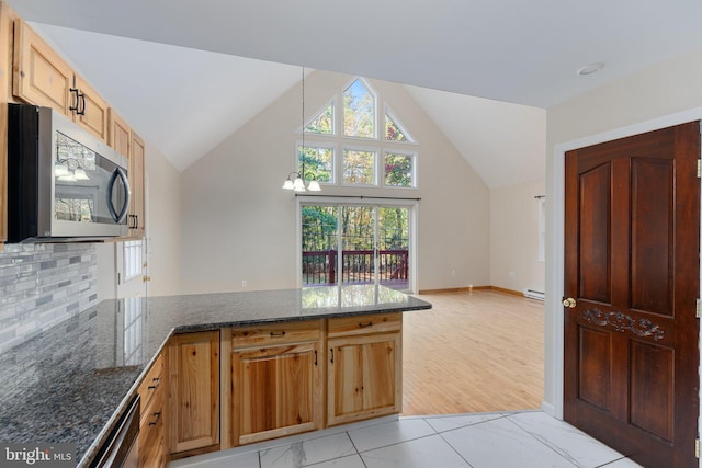 273 Four Seasons Dr, Drums, PA 18222 - kitchen with a peninsula, dark stone counters, stainless steel appliances, decorative backsplash, and a baseboard heating unit