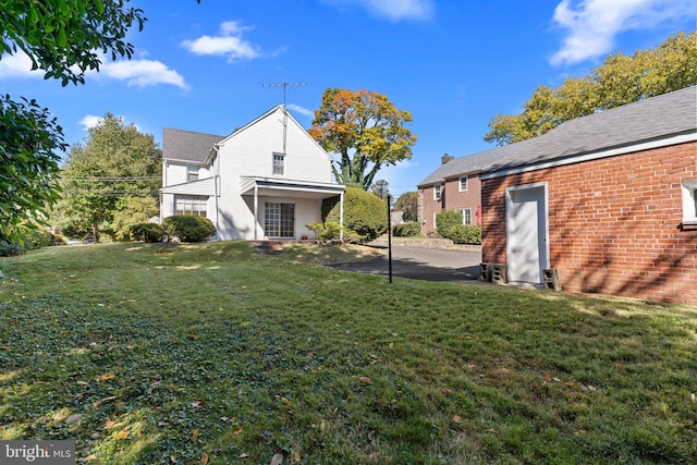 rear view of house featuring a patio and a lawn