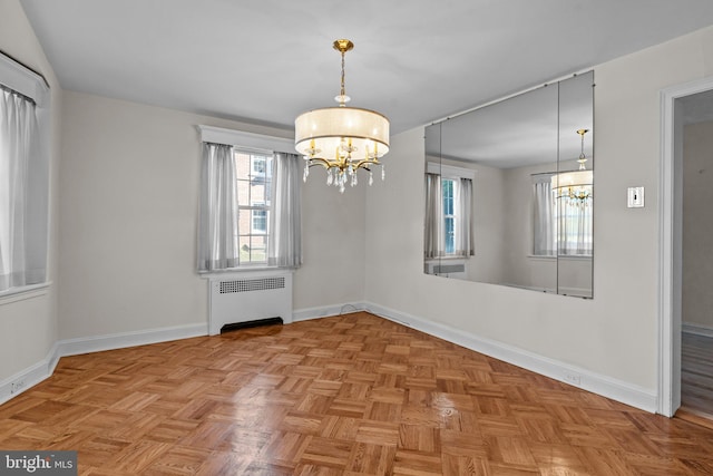 unfurnished dining area featuring radiator, a notable chandelier, and light parquet floors