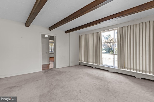 interior space with beamed ceiling, carpet, and a textured ceiling