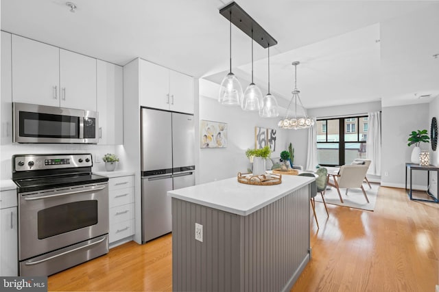 kitchen featuring a center island, light hardwood / wood-style flooring, decorative light fixtures, white cabinetry, and stainless steel appliances