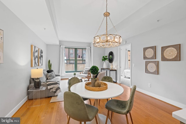 dining area featuring light hardwood / wood-style flooring and a notable chandelier