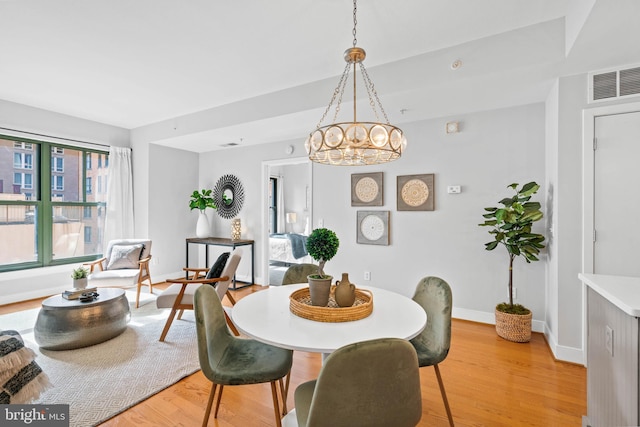 dining area featuring a chandelier and light wood-type flooring