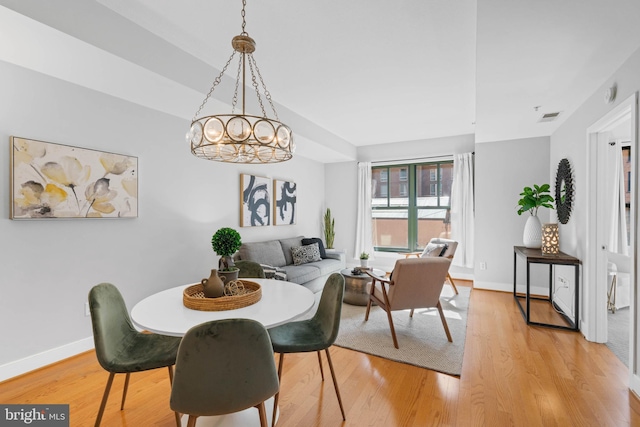 dining space featuring a chandelier and light wood-type flooring