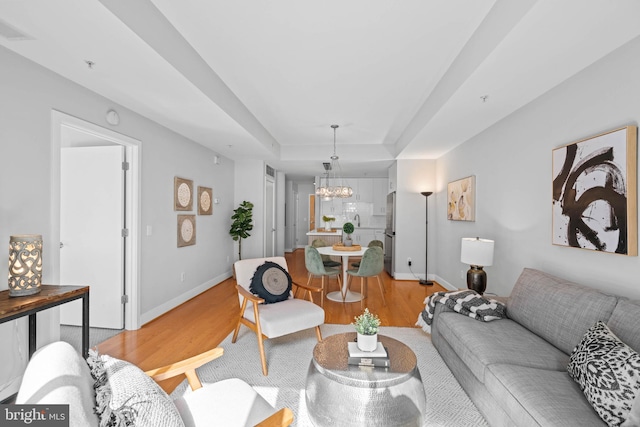 living room with a notable chandelier and light wood-type flooring