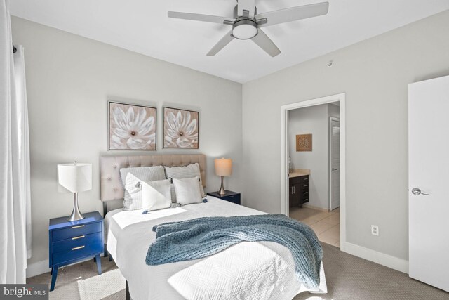 bedroom with light carpet, connected bathroom, and ceiling fan