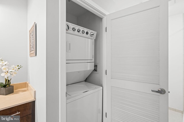 clothes washing area with stacked washer / dryer