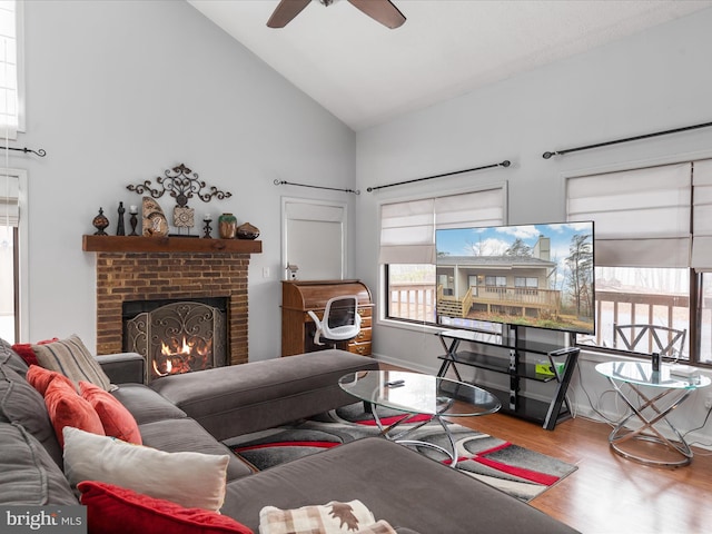 living room with wood-type flooring, a brick fireplace, high vaulted ceiling, and ceiling fan