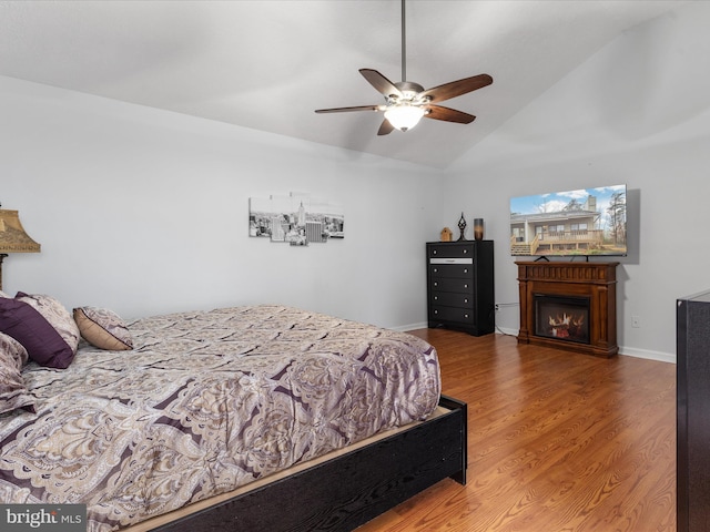 bedroom with lofted ceiling, hardwood / wood-style flooring, and ceiling fan