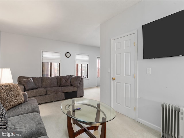 living room with radiator heating unit and light colored carpet