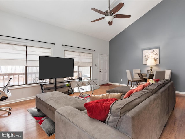 living room with ceiling fan, high vaulted ceiling, hardwood / wood-style flooring, and a healthy amount of sunlight