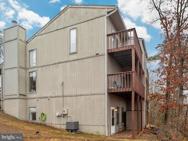 view of home's exterior with cooling unit and a balcony