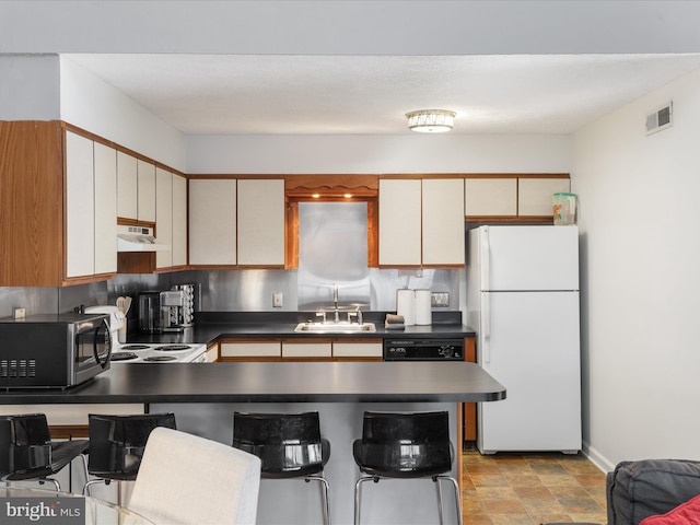 kitchen featuring range, decorative backsplash, white refrigerator, and sink