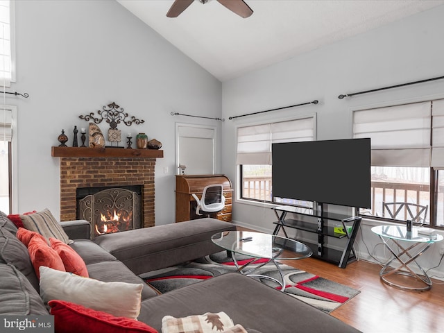 living room with a brick fireplace, high vaulted ceiling, ceiling fan, and hardwood / wood-style floors