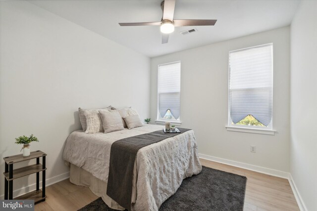 bedroom featuring multiple windows, ceiling fan, and light hardwood / wood-style flooring