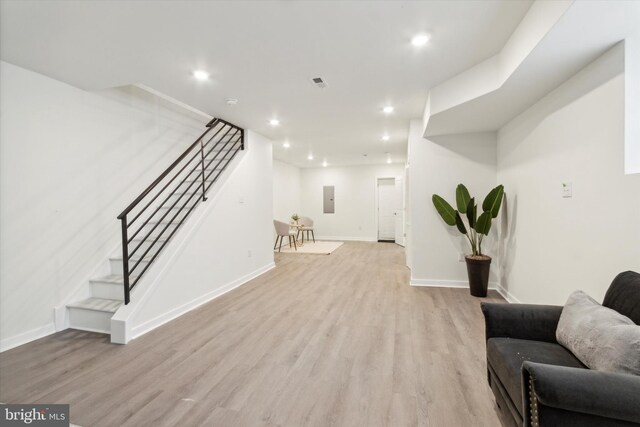 interior space featuring electric panel and light hardwood / wood-style floors