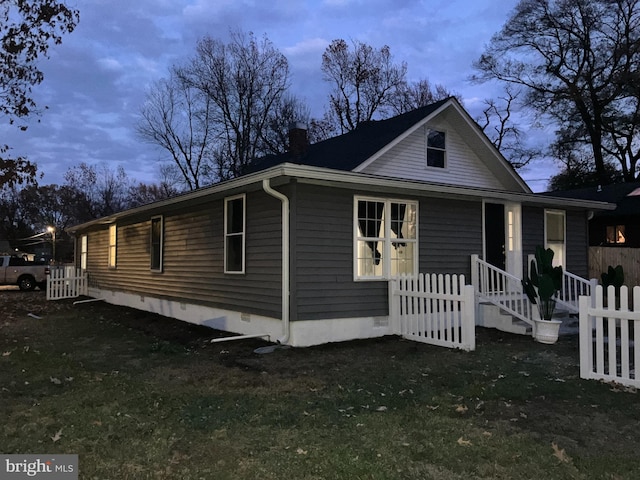 property exterior at dusk with a yard