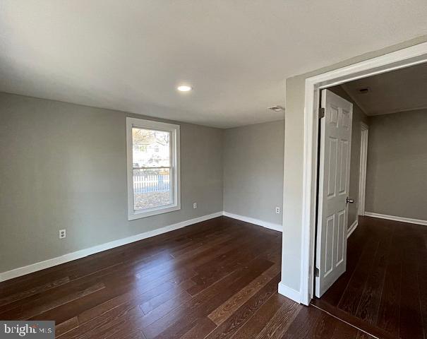 unfurnished room featuring dark wood-type flooring