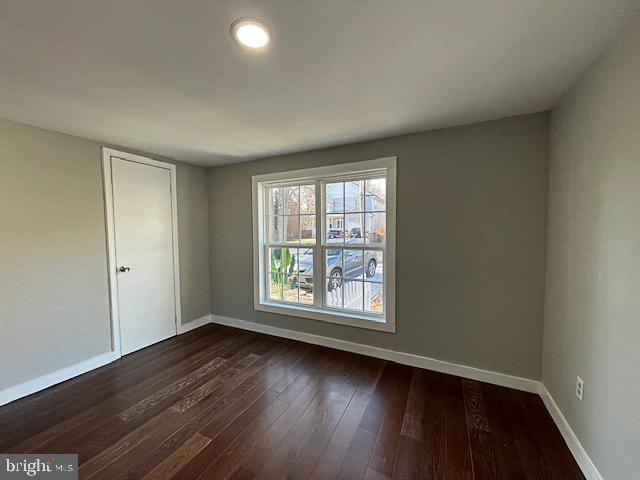 empty room with dark hardwood / wood-style flooring