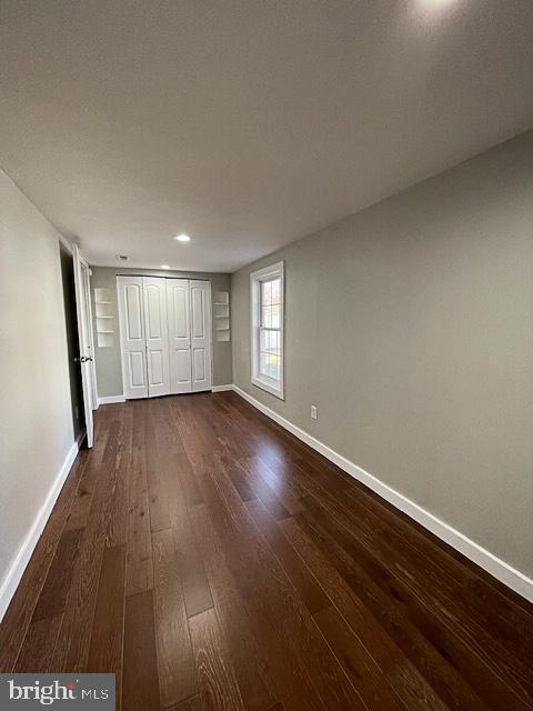 unfurnished bedroom featuring a closet and dark hardwood / wood-style flooring