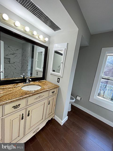 bathroom with hardwood / wood-style floors, vanity, and toilet