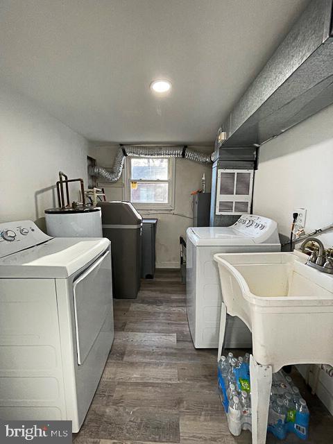 clothes washing area with water heater, dark hardwood / wood-style flooring, and independent washer and dryer