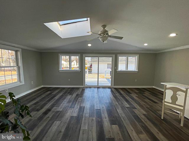 empty room featuring dark hardwood / wood-style flooring, a healthy amount of sunlight, and ornamental molding