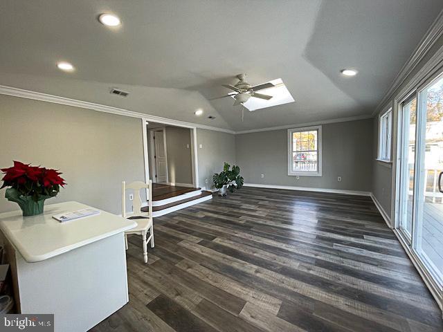 unfurnished room with dark hardwood / wood-style flooring, crown molding, plenty of natural light, and vaulted ceiling