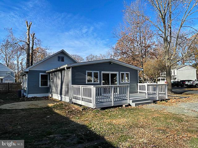 view of front of home with a front lawn and a wooden deck