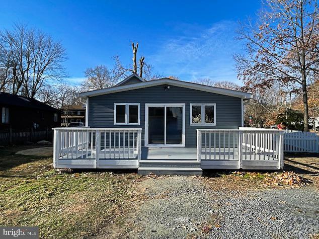 rear view of property featuring a wooden deck