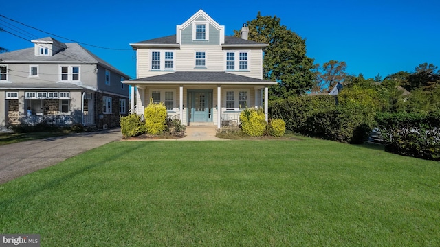 view of front facade with a front lawn and covered porch