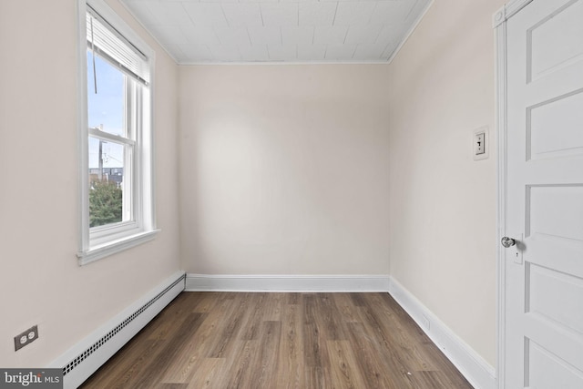 empty room with a baseboard radiator, ornamental molding, and dark hardwood / wood-style floors