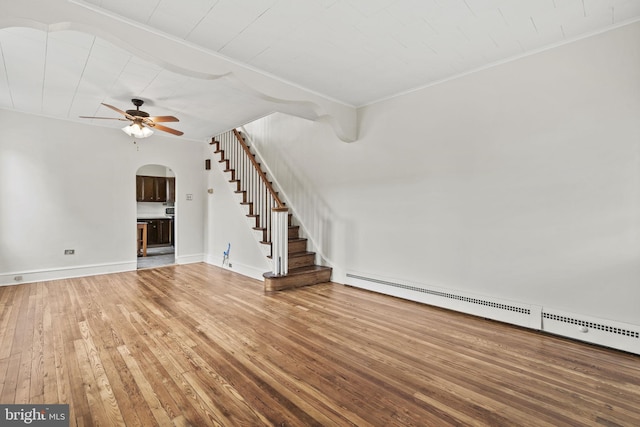 unfurnished living room featuring hardwood / wood-style floors, ceiling fan, and baseboard heating