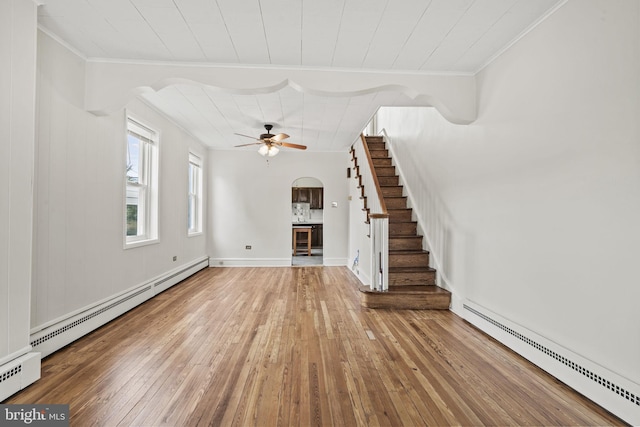 unfurnished living room featuring ceiling fan, wood-type flooring, and baseboard heating