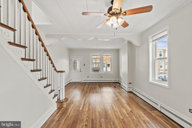 entrance foyer with a baseboard heating unit, hardwood / wood-style flooring, and a healthy amount of sunlight