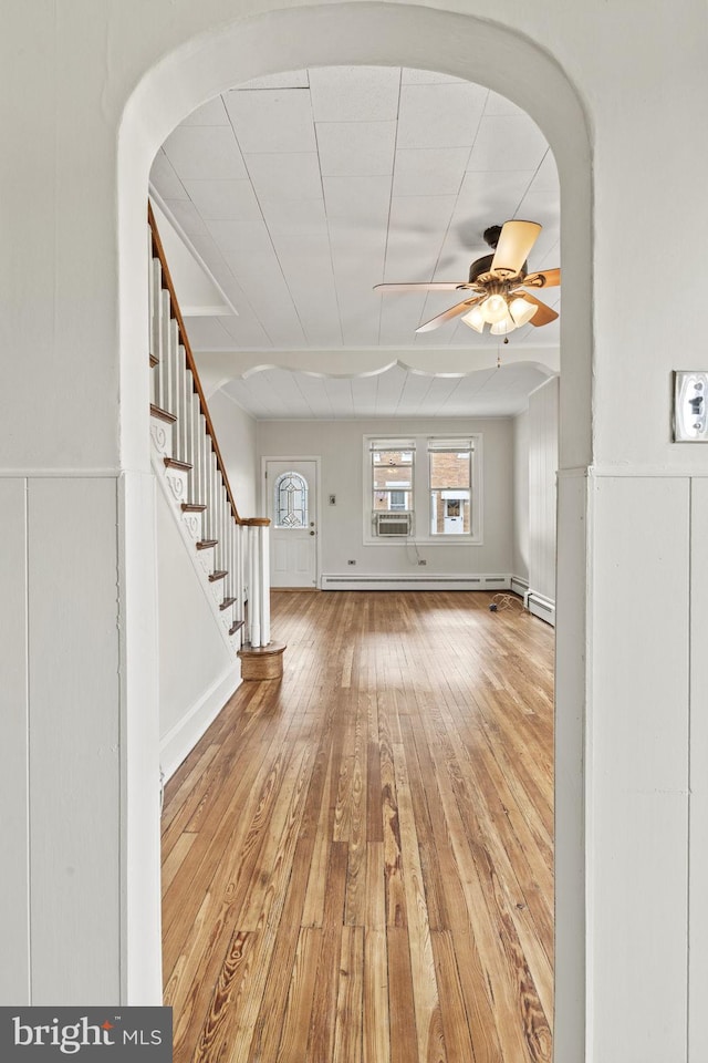 interior space with ceiling fan, light hardwood / wood-style flooring, cooling unit, and a baseboard radiator