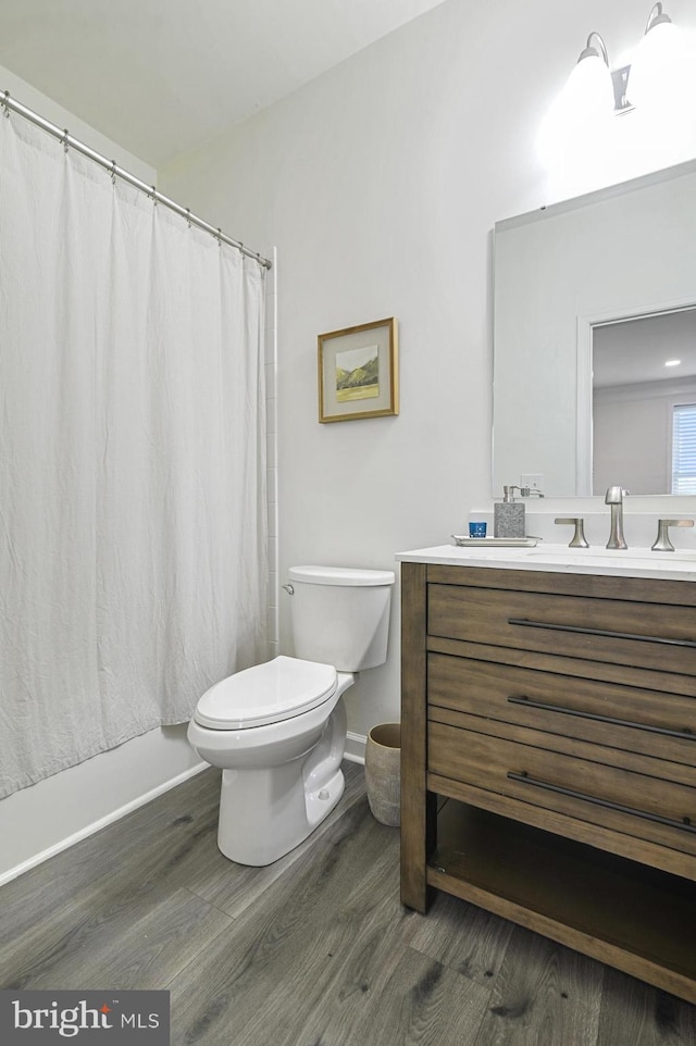 bathroom featuring vanity, hardwood / wood-style floors, and toilet