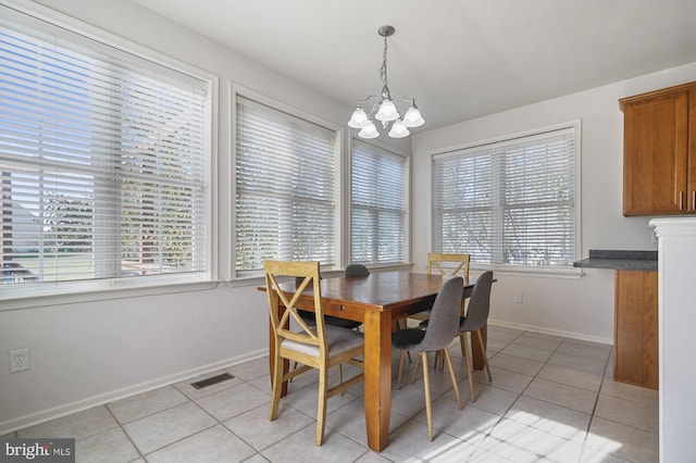 tiled dining space featuring an inviting chandelier