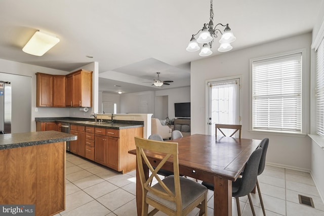 dining room with sink, ceiling fan with notable chandelier, and light tile patterned floors