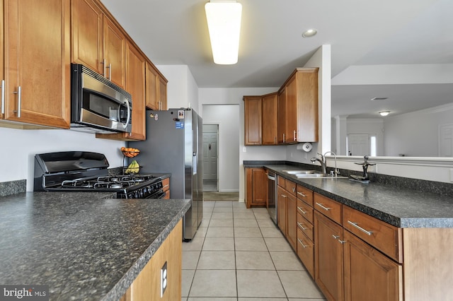 kitchen featuring sink, stainless steel appliances, light tile patterned flooring, decorative light fixtures, and kitchen peninsula