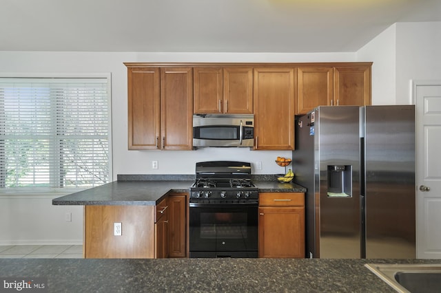 kitchen with stainless steel appliances and light tile patterned flooring