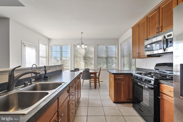 kitchen with sink, hanging light fixtures, stainless steel appliances, light tile patterned flooring, and a chandelier