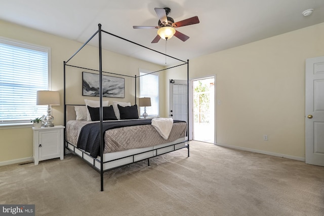 bedroom featuring access to exterior, light colored carpet, and ceiling fan