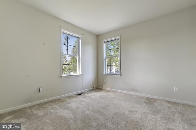 spare room featuring light colored carpet