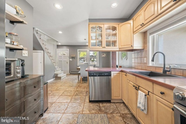 kitchen with decorative backsplash, light brown cabinets, sink, a baseboard radiator, and stainless steel appliances