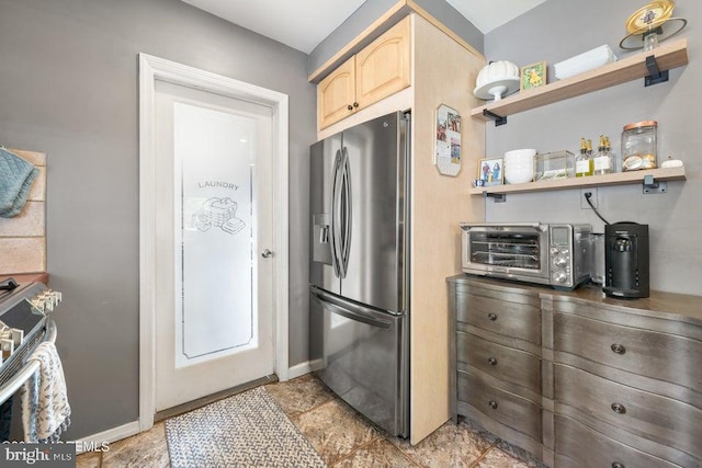 kitchen with light brown cabinets and stainless steel fridge