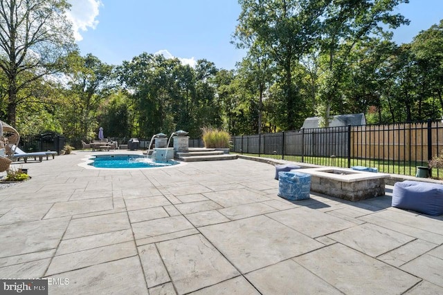 view of swimming pool featuring an outdoor fire pit, a patio area, and pool water feature