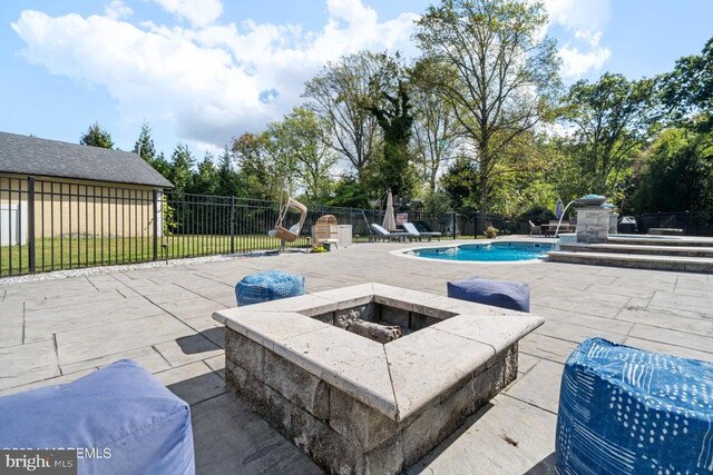 view of swimming pool featuring an outdoor fire pit and a patio