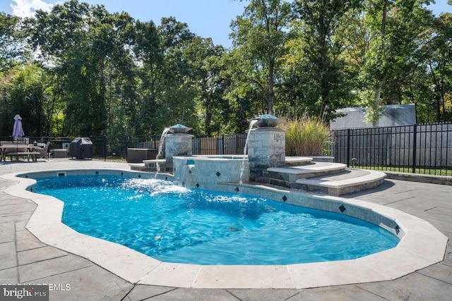 view of swimming pool featuring a patio, a hot tub, and pool water feature